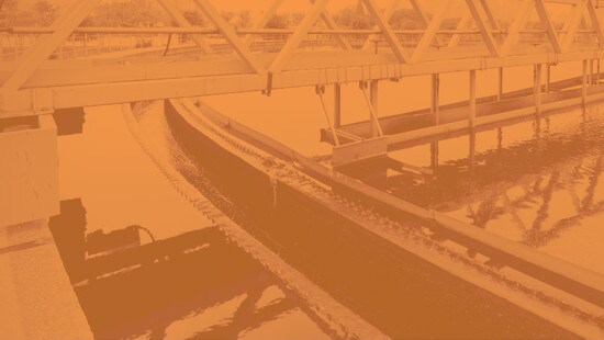 View of industrial water treatment site with orange hue over entire image.